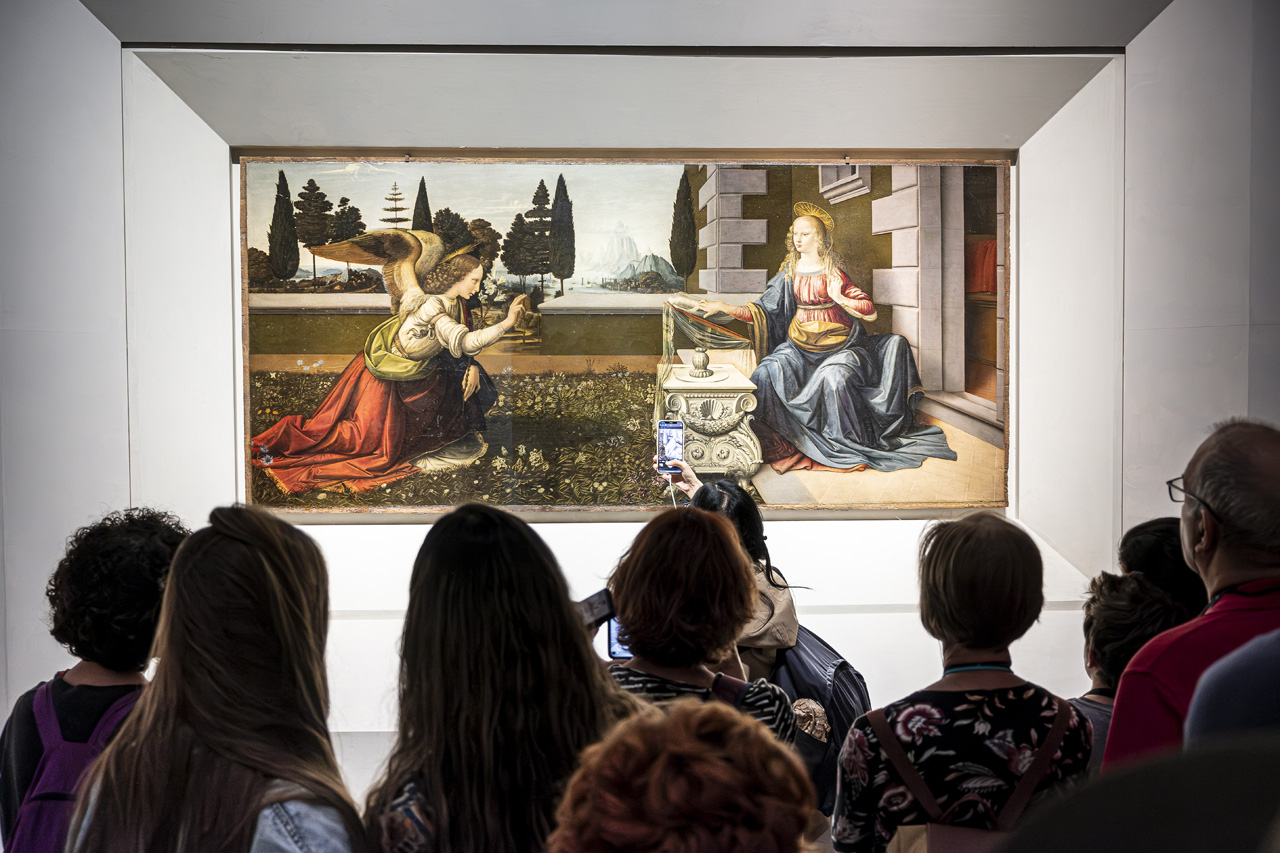Grupo de visitantes contemplando La Anunciación de Leonardo da Vinci