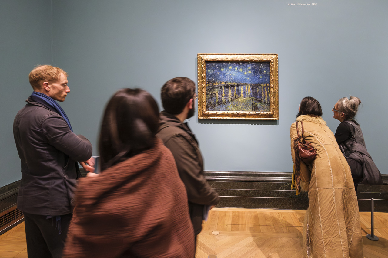 Visitantes contemplando La noche estrellada sobre el Ródano de Van Gogh