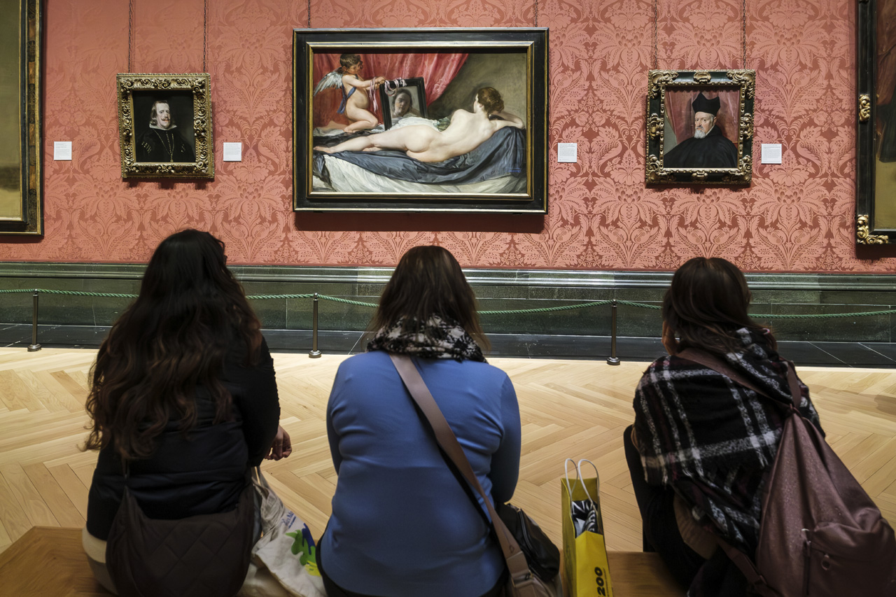 Tres mujeres sentadas frente a La Venus del espejo de Velázquez